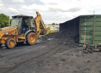 Trabalhadores iniciam retirada de carvão espalhado na BR-010 após carreta tombar e ficar atravessada na pista